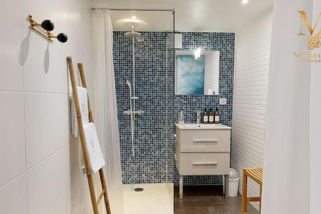 une salle de bain avec une douche avec un lavabo et un miroir dans l'établissement La Source d'Eugénie Vue Panoramique au Bugue, au Bugue