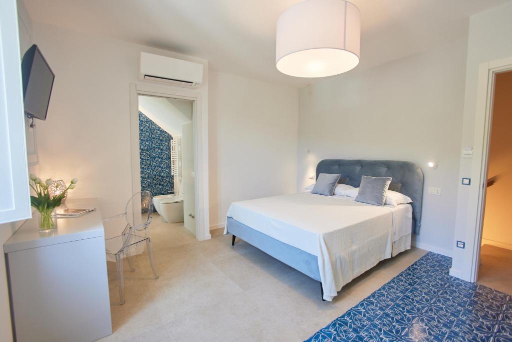 a bedroom with a white bed and a blue rug at BLUE BOUTIQUE in Vietri