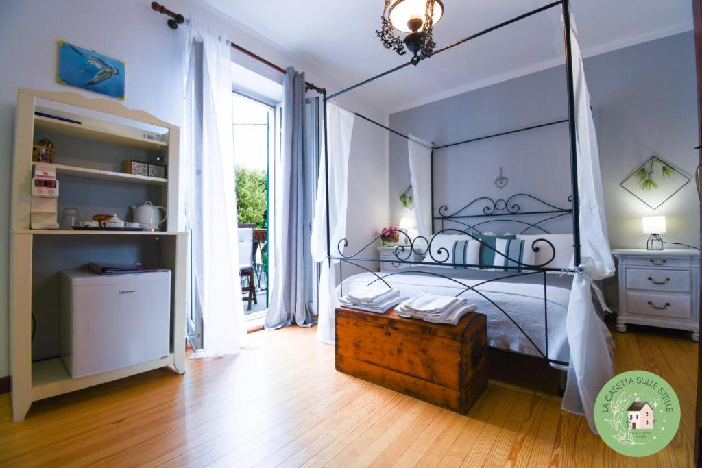 1 dormitorio con cama con dosel y suelo de madera en La casetta sulle Stelle, en Stella