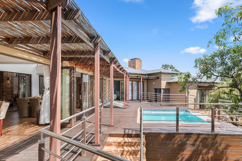 una terraza al aire libre con piscina y una casa en Elements Private Golf Reserve House 197, en Bela-Bela