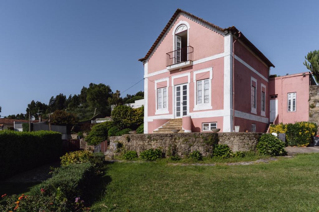uma casa cor-de-rosa com uma janela no topo de um quintal em Villa with private pool and garden by Go2oporto em Terroso