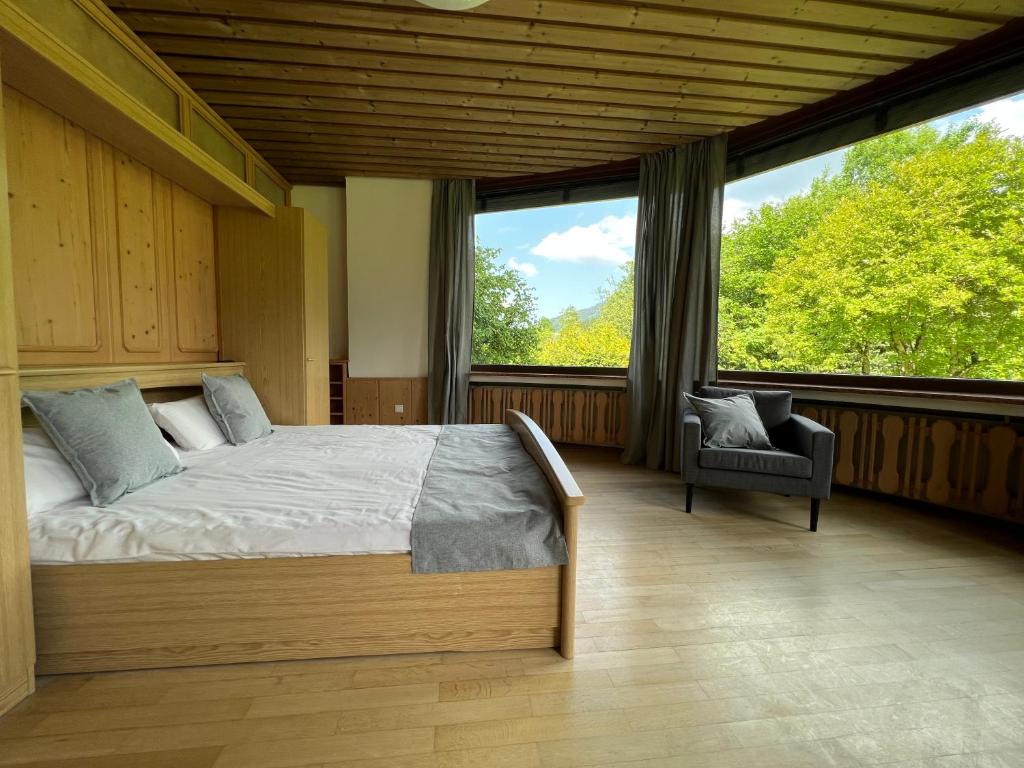 a bedroom with a bed and a large window at Aparthotel Hochfeld in Schönau am Königssee