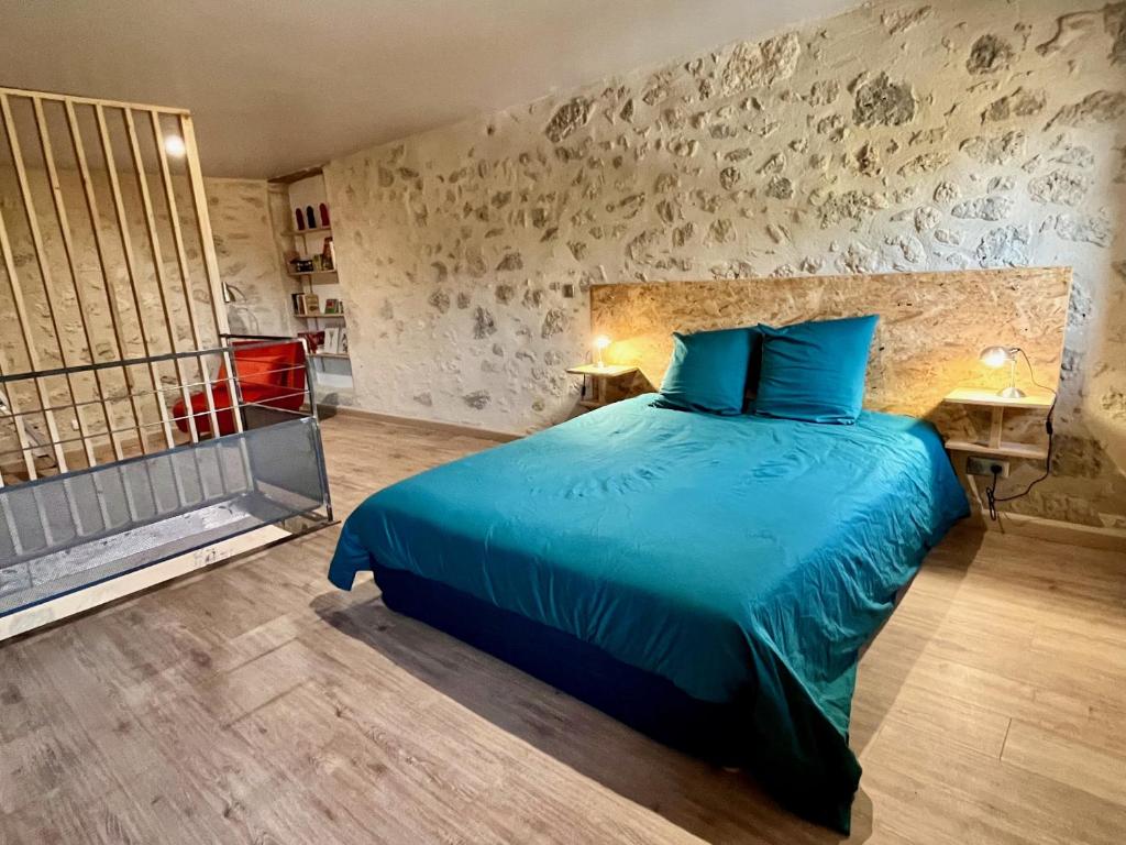 - une chambre avec un lit et une couette bleue dans l'établissement Borderie de Vérone, à Espiens