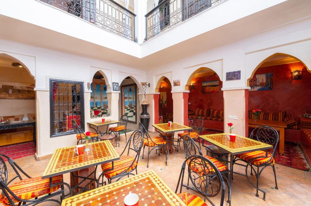 un restaurante vacío con mesas y sillas en Riad M'boja "Chez Ali Baba", en Marrakech