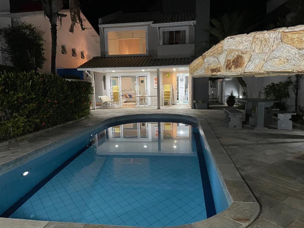 ein Schwimmbad vor einem Haus in der Nacht in der Unterkunft Casa de praia em Riviera no Módulo 21 in Bertioga