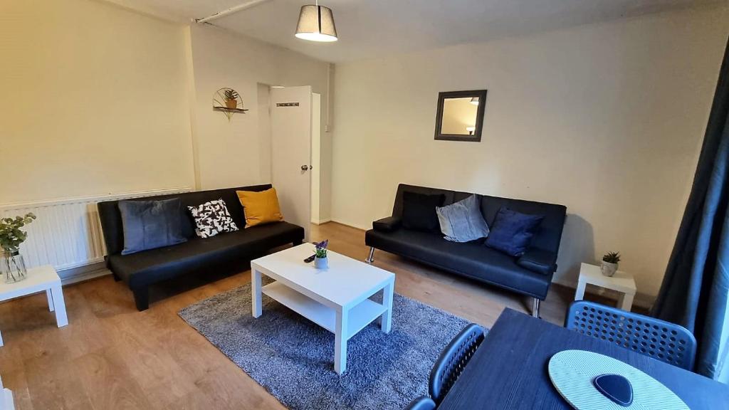 a living room with two couches and a table at 2 Bedroom apartment in Kennington London in London