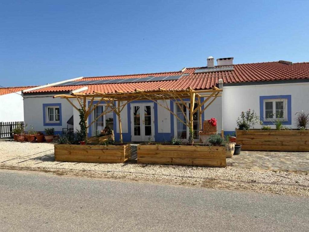 a small white house with a red roof at Casa Presente Guesthouse in Carrapateira