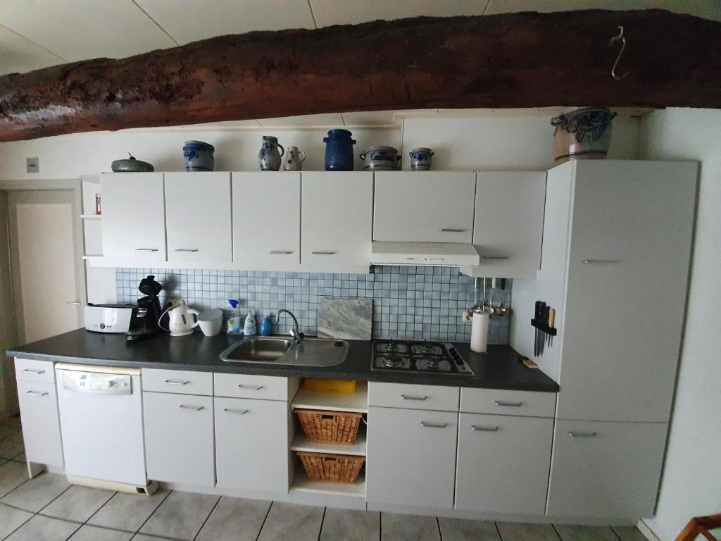 een keuken met witte kasten en een aanrecht bij Ferienhaus Gapinge Walcheren Zeeland in Veere
