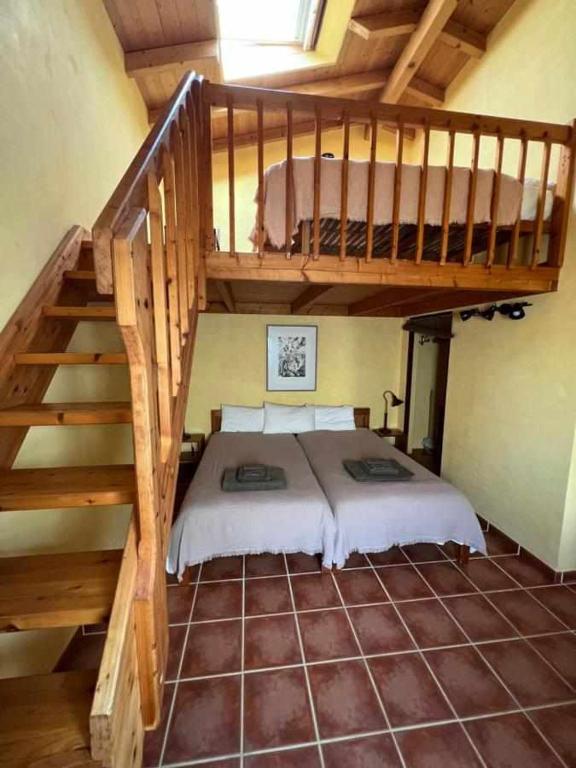 a bedroom with a bunk bed and a staircase at Casa Presente Guesthouse in Carrapateira