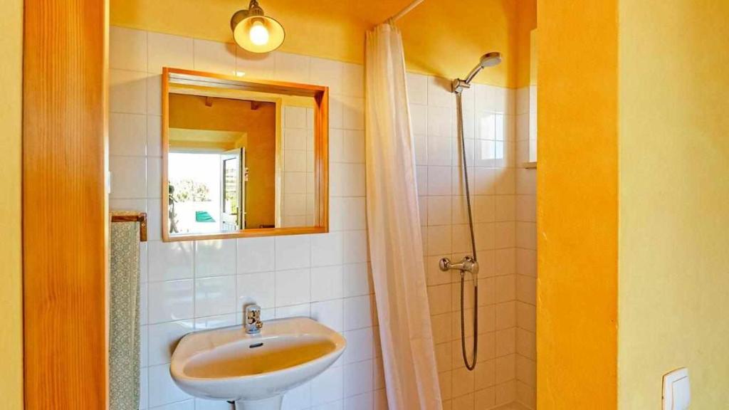 a bathroom with a sink and a shower at Casa Presente Guesthouse in Carrapateira