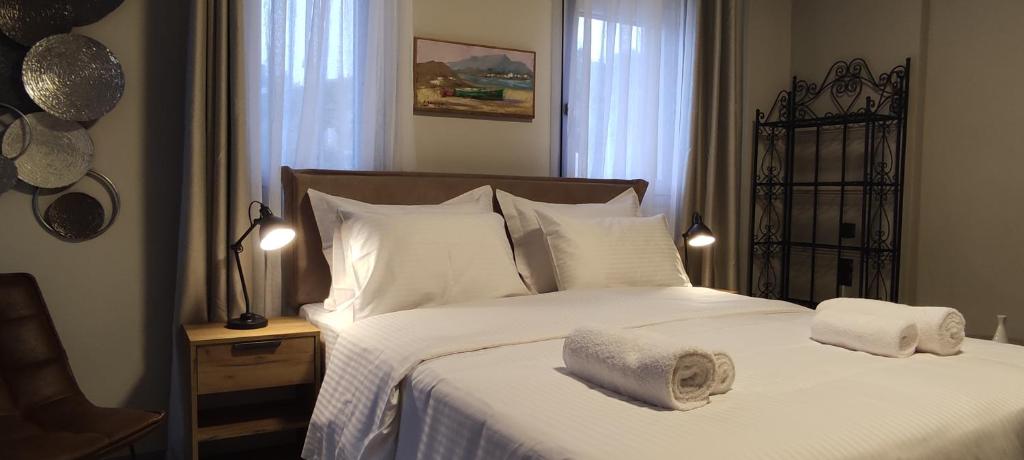 a bedroom with a white bed with towels on it at Cruzeto in Syvota