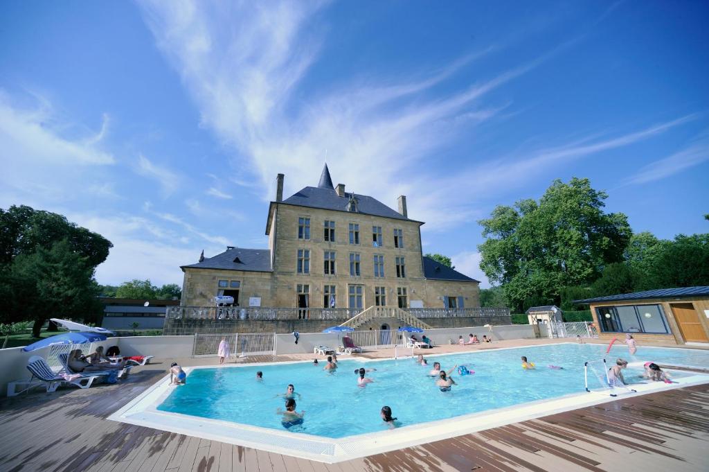 a group of people in a swimming pool in front of a building at ULVF Le Domaine de Pelvezy in Saint-Geniès