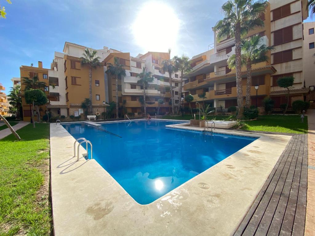 een zwembad voor een appartementencomplex bij New apartment with sea view and pool in Torrevieja
