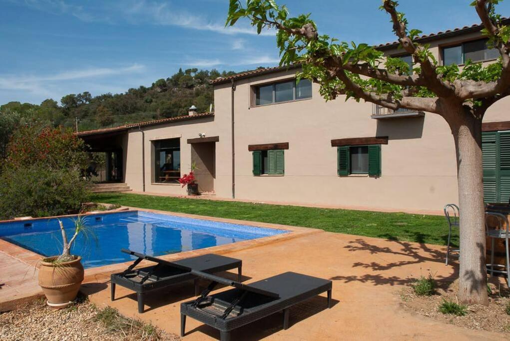 uma casa com piscina em frente a uma casa em Cal Cabrer em Masarach