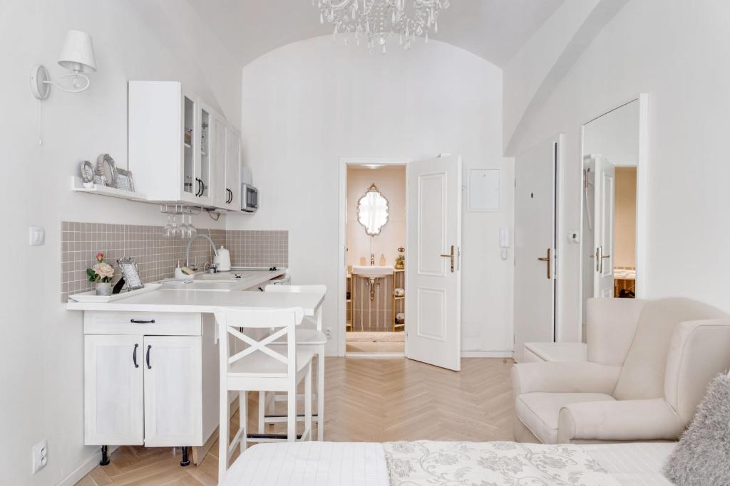 a white kitchen with a sink and a table at Apartments With The Lions in Prague