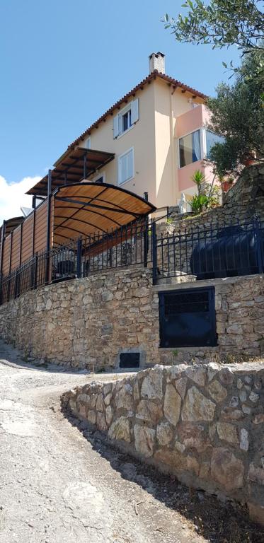 una pared de piedra frente a una casa en Margherita's holidays home en Agios Spiridon Fokidas