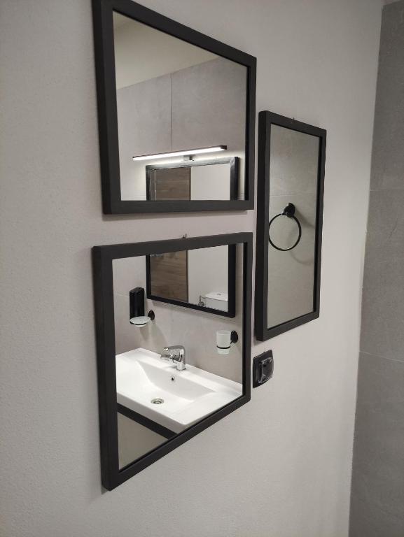 a bathroom with a sink and two mirrors on the wall at Cruzeto in Syvota