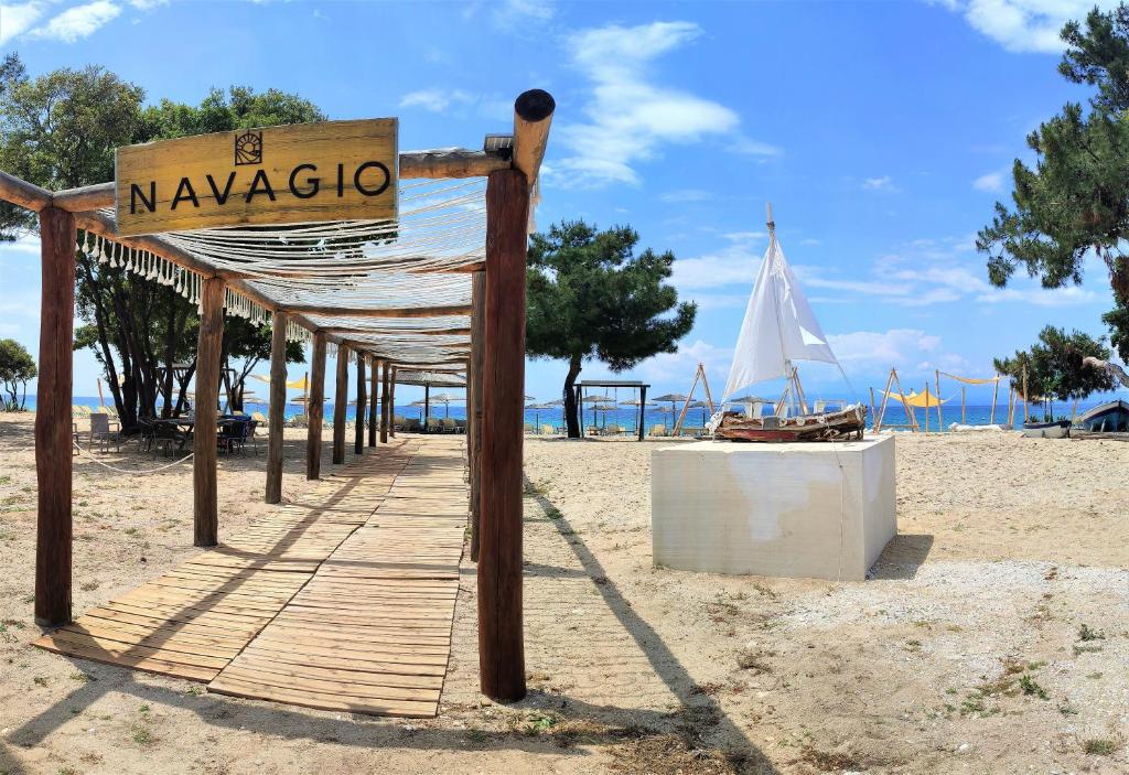 a sign for a beach with a white umbrella at Thasos Blue Apartments in Prinos