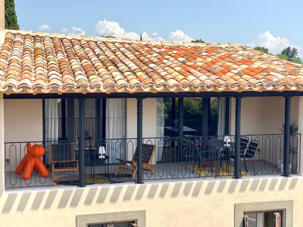 balkon z krzesłami i pomarańczową figurką w obiekcie Gîte au pied de la Cité Médiévale - Le 127 w Carcassonne