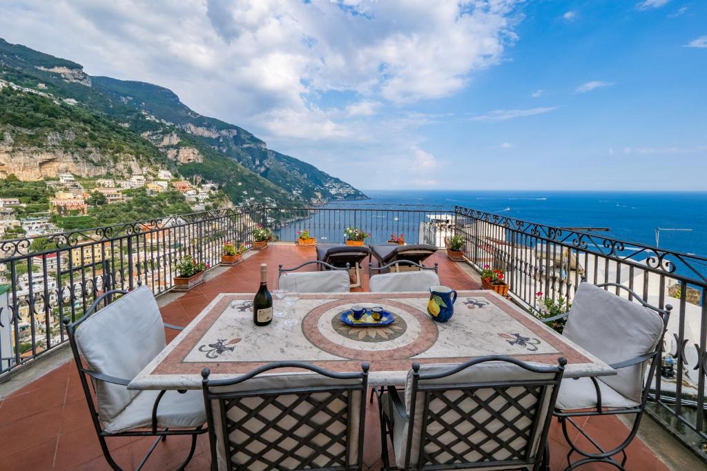 a table on a balcony with a view of the ocean at A casa di Antonio in Positano