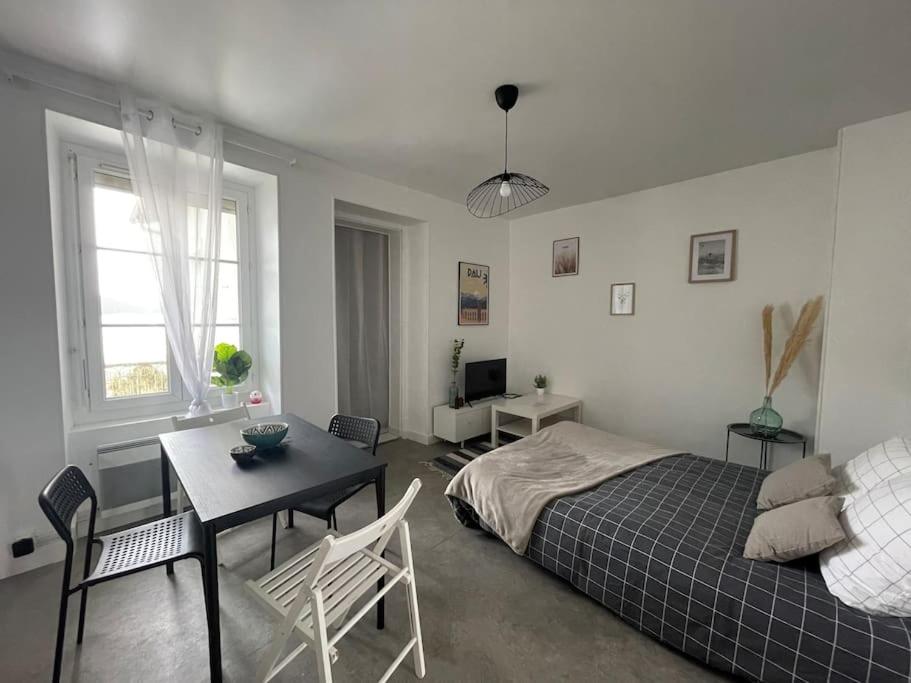 une chambre avec un lit, une table et des chaises dans l'établissement Bizanos - 4 pers, wifi, balcon, à Bizanos