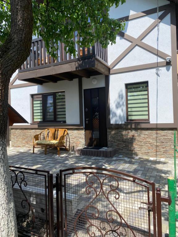 ein Haus mit einem Balkon und einer Bank auf einer Terrasse in der Unterkunft Коттедж У Анютки in Truskawez