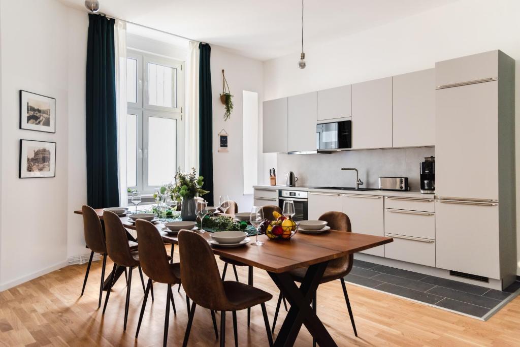 een keuken en eetkamer met een houten tafel en stoelen bij 165m2 Downtown Family Suite 5BR, 3Bath, kids room, 11min Alexanderplatz in Berlijn