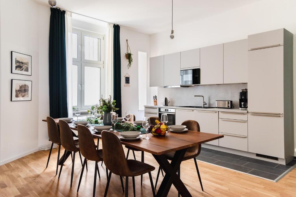 cocina y comedor con mesa de madera y sillas en 165m2 Downtown Family Suite 5BR, 3Bath, kids room, 11min Alexanderplatz, en Berlín