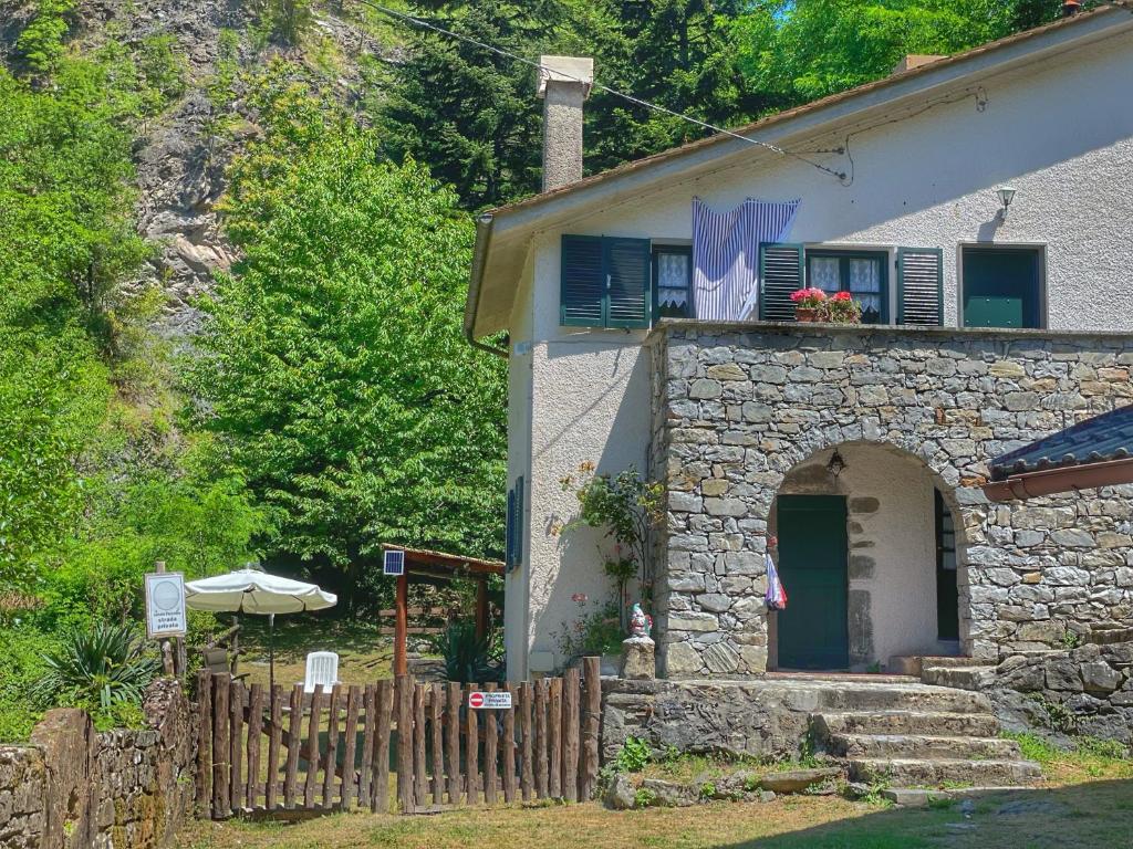 une maison avec une clôture devant elle dans l'établissement Villa con bosco giardino e ruscello ad uso esclusivo, à Borzonasca