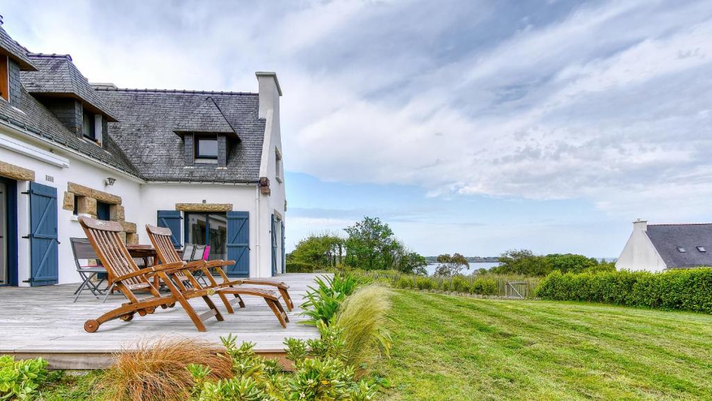 une terrasse avec 2 chaises et une maison dans l'établissement Grande villa 6 personnes à 200m de la mer . Récemment rénovée., à Moëlan-sur-Mer