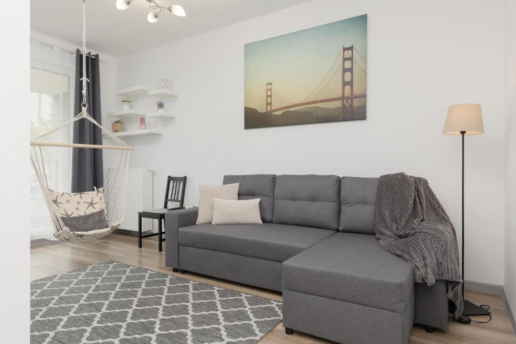 a living room with a couch and a bridge painting on the wall at Apartment Warsaw Goclaw & 2 bedrooms & Parking & Balcony by Renters in Warsaw