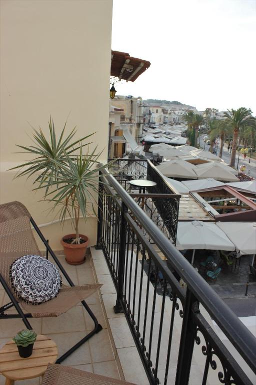 a balcony with a bunch of tables and chairs at Théa Apartment in Rethymno