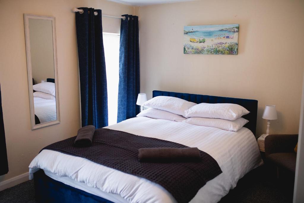 a bedroom with a large bed with pillows and a mirror at Vanity Ballycastle Diamond 2 bedroom apartment in Ballycastle