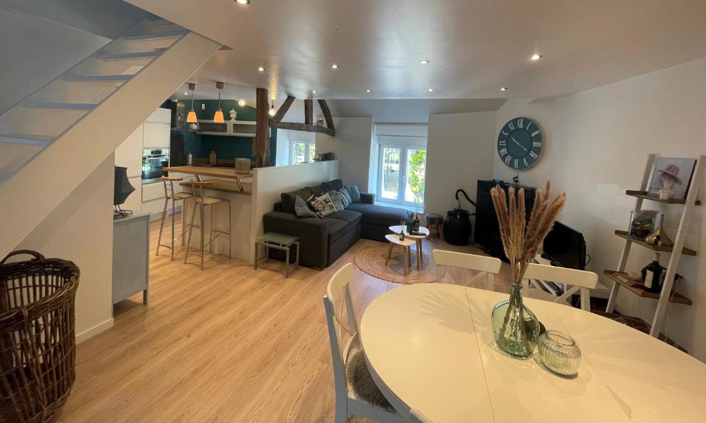 a living room with a dining room table and a kitchen at Gîte "Au Fourneau" in Spa