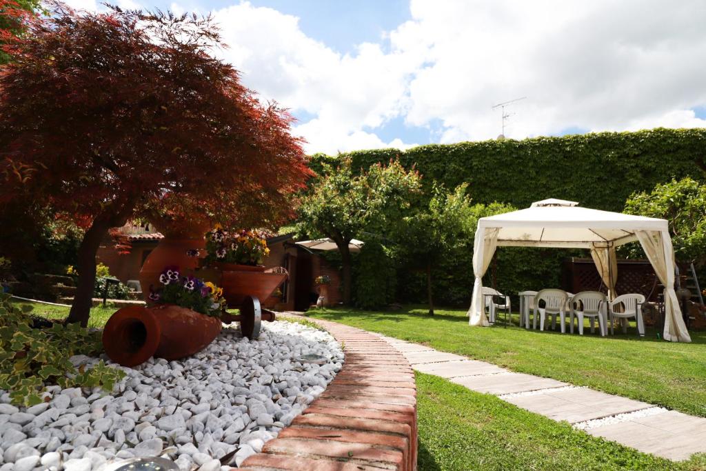 a garden with a white umbrella and a table and chairs at Villa Roberta B&B in Ferrara