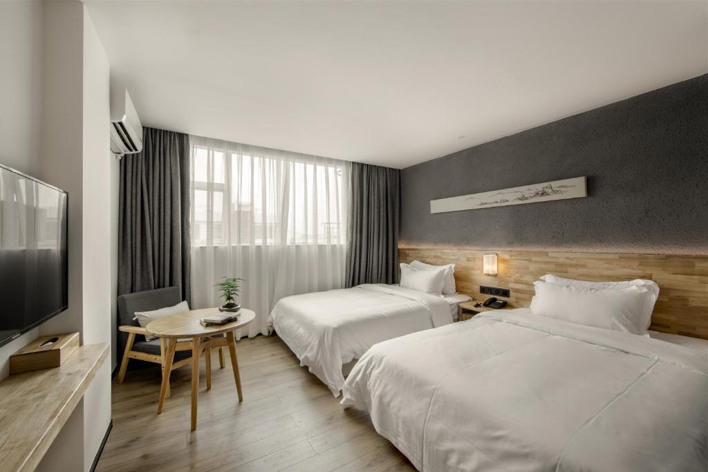 Postel nebo postele na pokoji v ubytování Guangzhou Shug Art Hotel