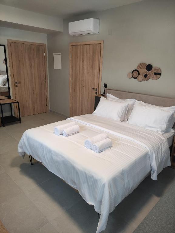 a large white bed with two towels on it at Cruzeto in Syvota