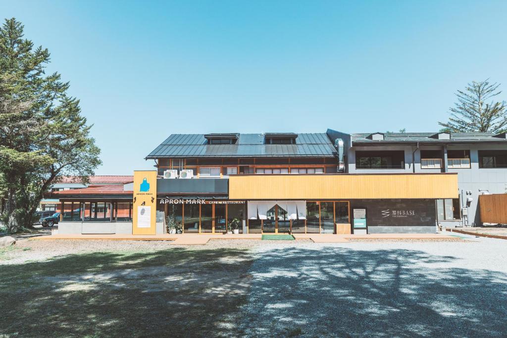 ein Gebäude mit einem Parkplatz davor in der Unterkunft 蓼科BASE kitchen,spa&hotel in Chino