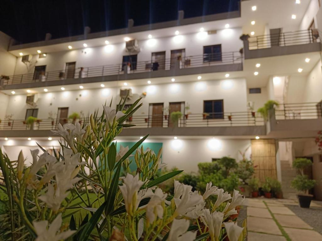 a building with white flowers in front of it at Green Club Farm in Ajmer