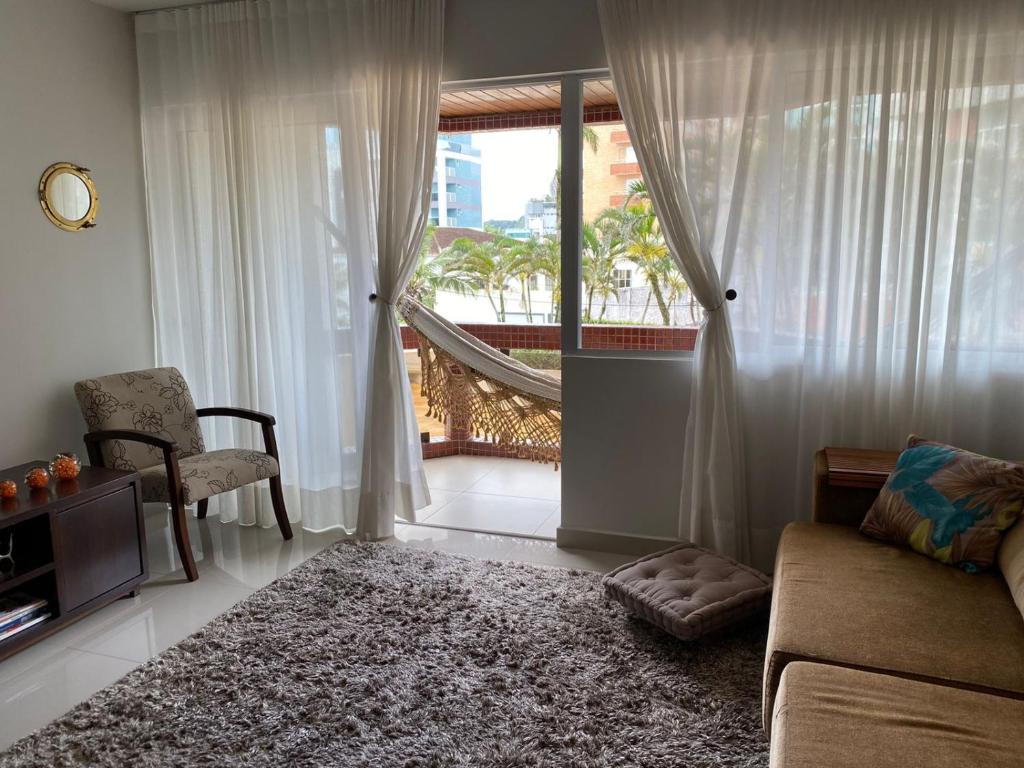 a living room with a couch and a chair and a window at Apto todo equipado em Caiobá há 50m do mar in Matinhos