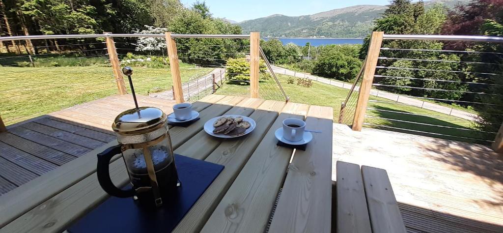 a table on a deck with a plate of food on it at Highland Haven, Glencoe in Ballachulish