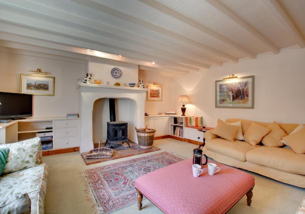 a living room with a couch and a fireplace at Byre Cottage in Langham