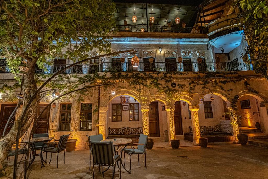 a patio with tables and chairs in front of a building at Goreme House in Goreme