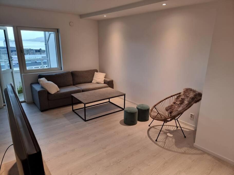 ein Wohnzimmer mit einem Sofa und einem Stuhl in der Unterkunft Apartment nearby sentrum in Bergen
