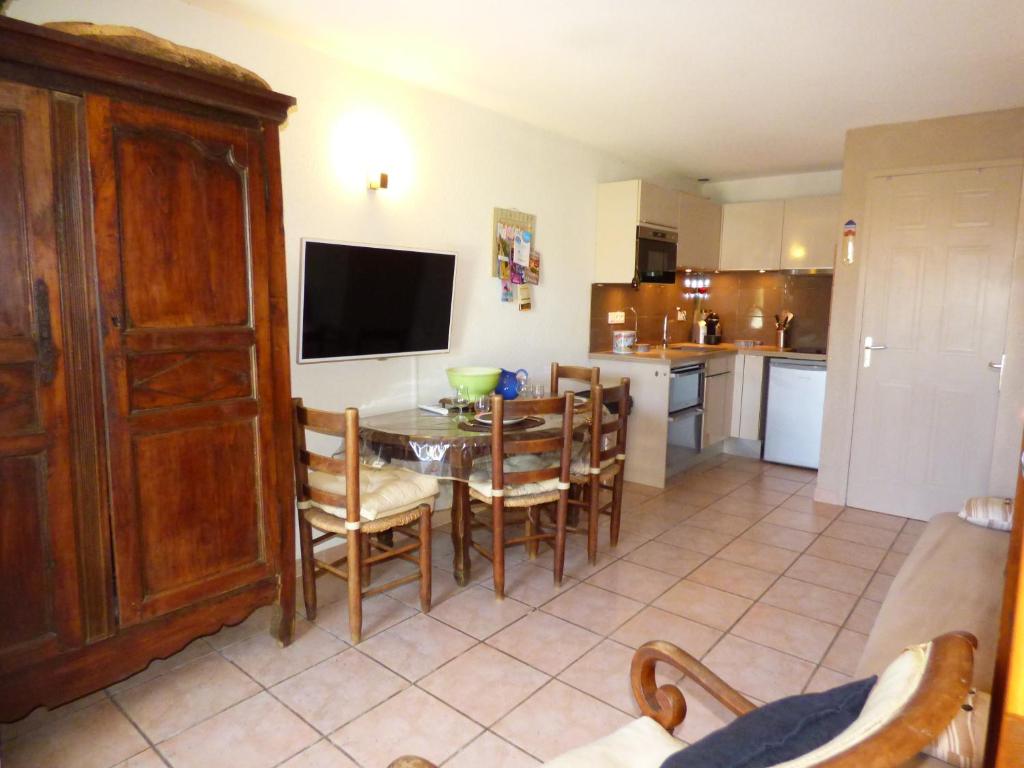 a kitchen and dining room with a table and chairs at Les Jardins d&#39;Ulysse, Pavillon T3, terrasse &amp; parking, Narbonne Plage in Narbonne-Plage