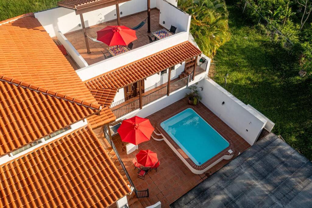 an aerial view of a house with a swimming pool and umbrellas at Casa Colibri + Casita - Villa w/ocean views in Vieques