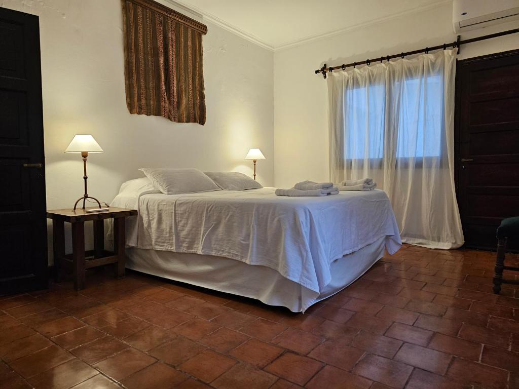 a bedroom with a white bed and a window at Lo de Leo in Salta