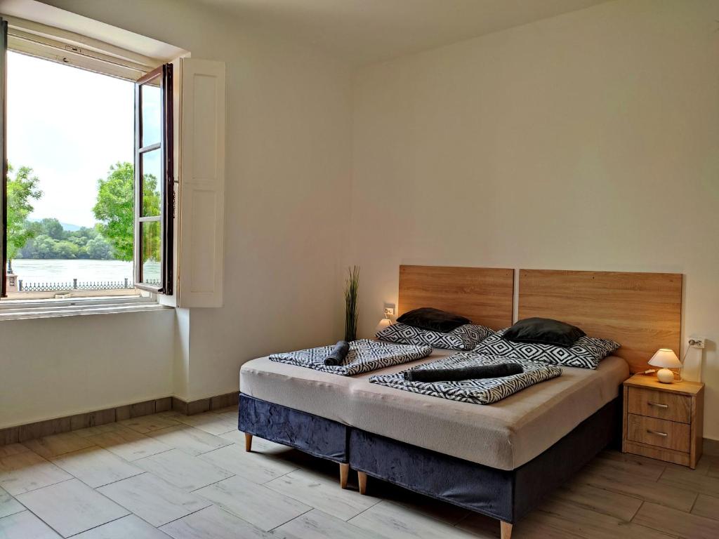 a bedroom with a bed with a large window at Panoráma Apartman in Vác