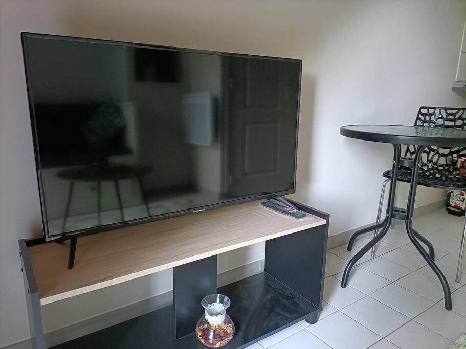 uma grande televisão de ecrã plano em cima de uma mesa em Agréable et paisible studio em Franqueville-Saint-Pierre
