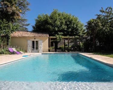 ein großer blauer Pool vor einem Haus in der Unterkunft Gîte avec piscine privatisée in Chamaret